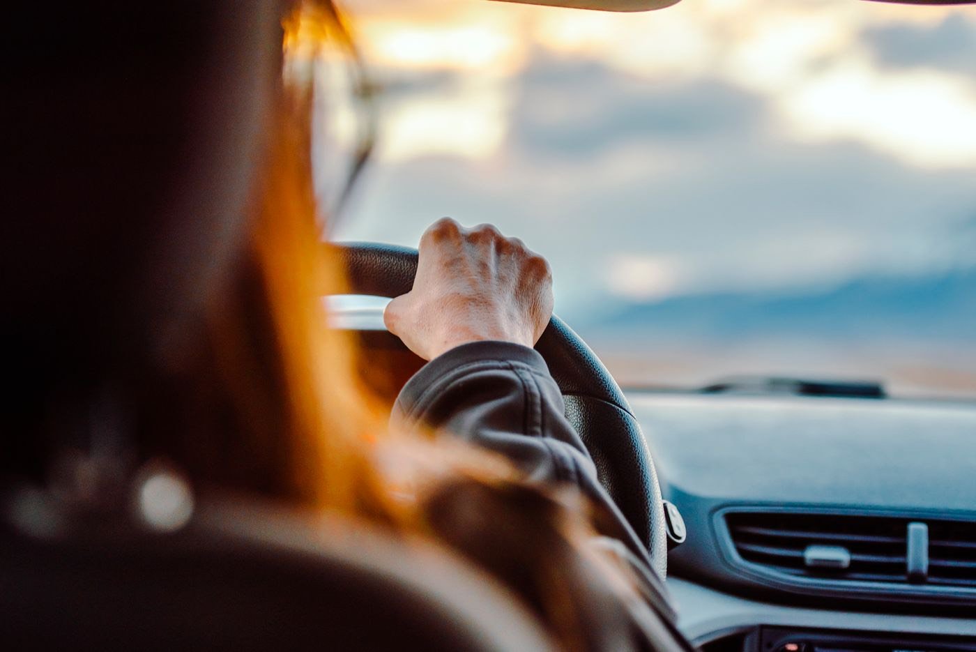 Vairuotoja prie automobilio vairo